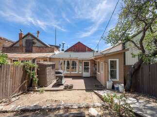 Enjoy outdoor living in this charming backyard featuring a spacious deck perfect for entertaining, complete with a grill and a convenient storage shed.