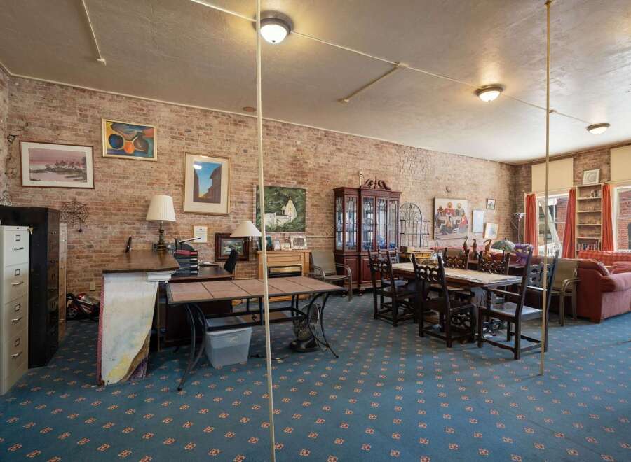 This spacious room features exposed brick walls, creating a rustic and inviting atmosphere.