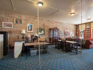 This spacious room features exposed brick walls, creating a rustic and inviting atmosphere.