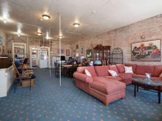 Discover this spacious living area featuring exposed brick walls and a large, comfortable sectional sofa perfect for gatherings.