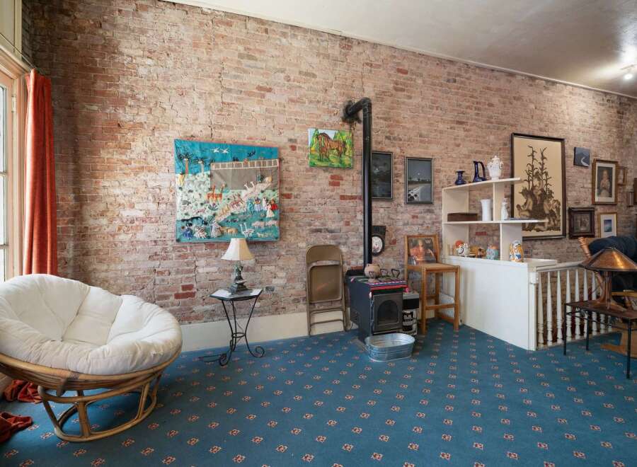 Exposed brick walls and a rustic wood-burning stove create a cozy atmosphere in this unique living space.
