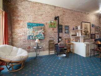 Exposed brick walls and a rustic wood-burning stove create a cozy atmosphere in this unique living space.
