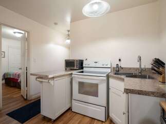 This charming kitchen features a full-sized electric range and a compact toaster oven, perfect for preparing meals.