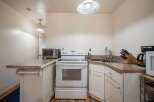Discover this charming kitchen featuring a sleek white electric range and a convenient countertop toaster oven.