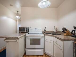Discover this charming kitchen featuring a sleek white electric range and a convenient countertop toaster oven.