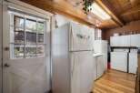 This charming kitchen features a spacious white refrigerator and ample cabinet space, perfect for all your culinary needs.