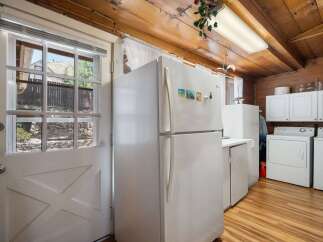 This charming kitchen features a spacious white refrigerator and ample cabinet space, perfect for all your culinary needs.