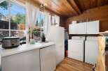 This charming laundry room features a spacious countertop with a Crock-Pot and a plant, perfect for multitasking.