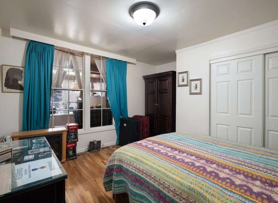 This charming bedroom features a cozy atmosphere with a vibrant, patterned quilt on the bed.