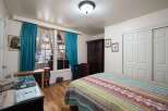 This charming bedroom features a cozy atmosphere with a vibrant, patterned quilt on the bed.