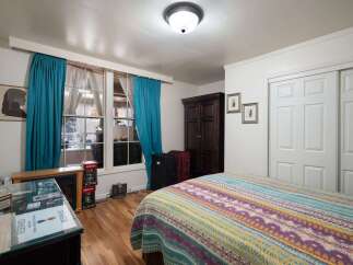 This charming bedroom features a cozy atmosphere with a vibrant, patterned quilt on the bed.