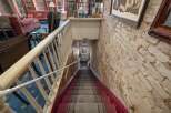 Descend into this charming space via a carpeted staircase with a classic red runner and ornate railing.