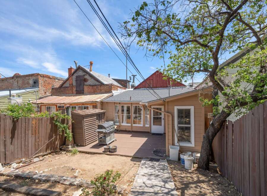 Enjoy outdoor living in this charming backyard featuring a spacious deck perfect for entertaining, complete with a grill and a convenient storage shed.