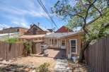 Enjoy outdoor living in this charming backyard featuring a spacious deck perfect for entertaining, complete with a grill and a convenient storage shed.