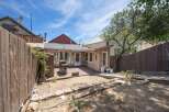 Enjoy outdoor living in this charming backyard featuring a spacious deck perfect for entertaining and a grill ready for summer cookouts.
