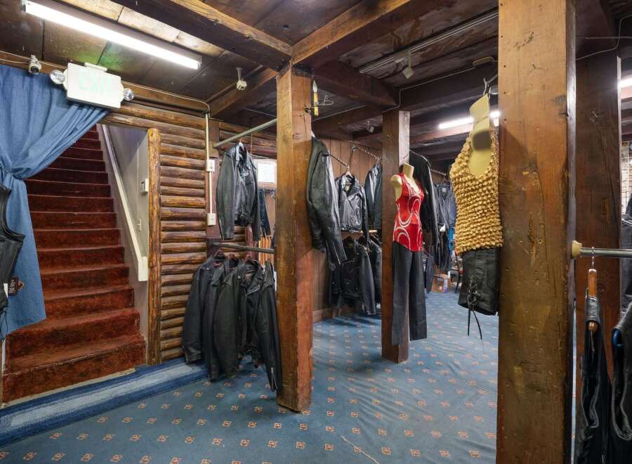 Discover a unique retail space with a rustic, log-cabin aesthetic, perfect for a motorcycle apparel store.