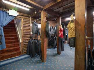 Discover a unique retail space with a rustic, log-cabin aesthetic, perfect for a motorcycle apparel store.