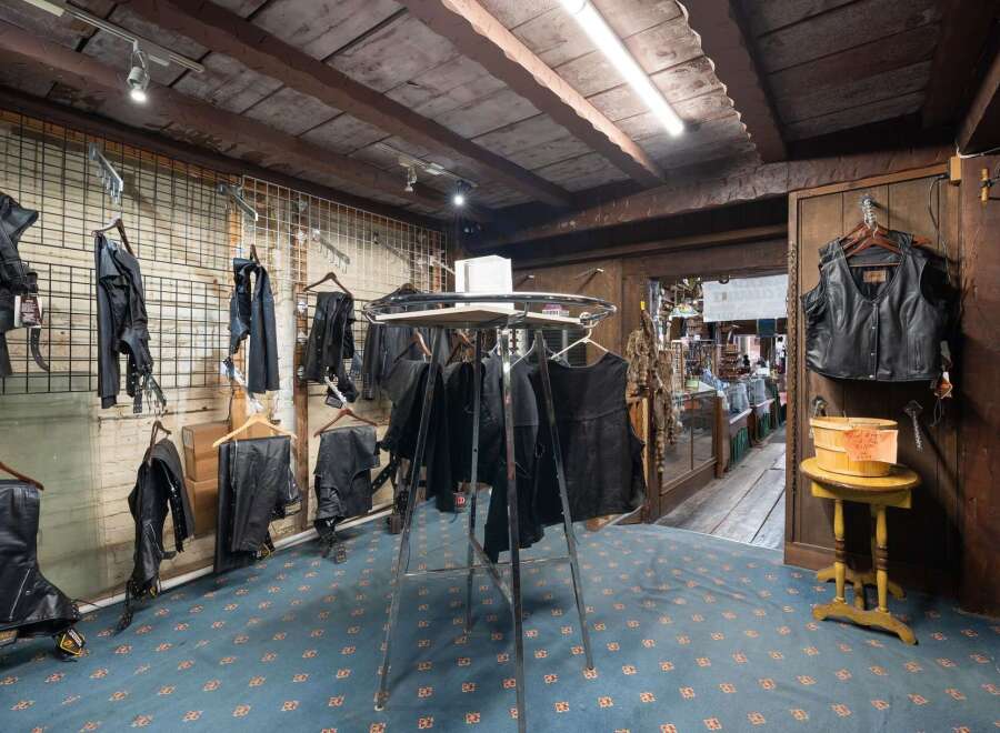 Explore this unique retail space, perfect for a motorcycle apparel store, featuring a rustic wooden ceiling and exposed beams.