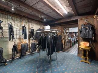 Explore this unique retail space, perfect for a motorcycle apparel store, featuring a rustic wooden ceiling and exposed beams.