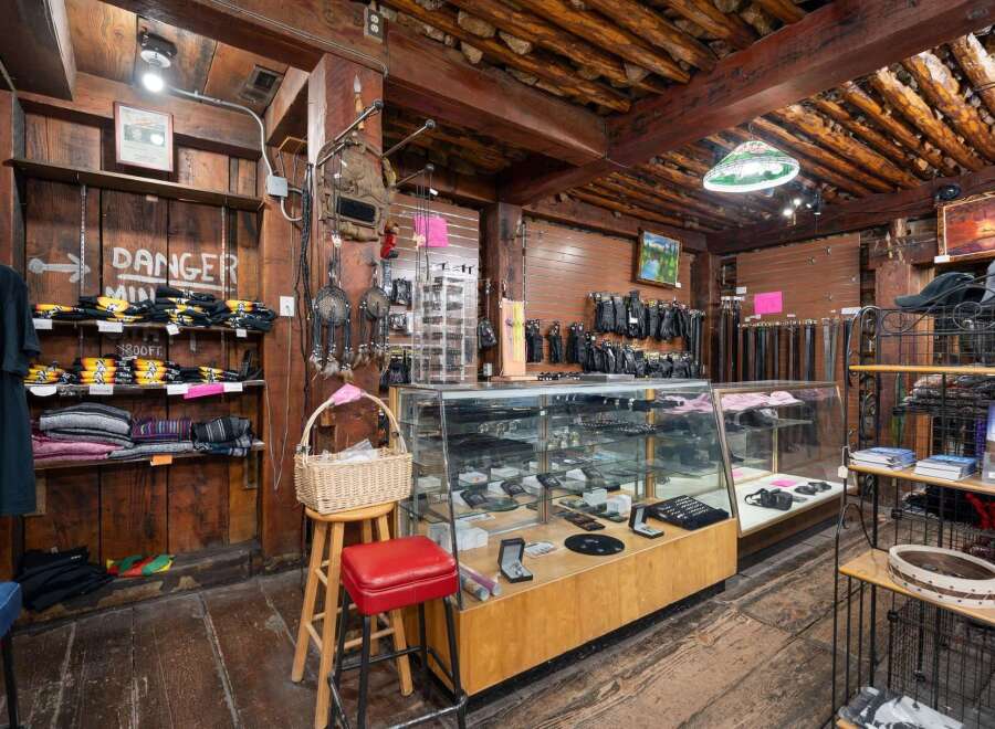 Discover a unique retail space with rustic charm, featuring exposed wooden beams and a log ceiling.