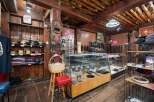 Discover a unique retail space with rustic charm, featuring exposed wooden beams and a log ceiling.