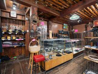 Discover a unique retail space with rustic charm, featuring exposed wooden beams and a log ceiling.