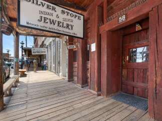 Step back in time with this historic storefront, featuring the 'Silver Stop' Indian & Silver Jewelry shop and a classic saloon.