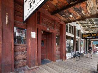 Step back in time with this historic property featuring rustic log construction and a charming wooden boardwalk.
