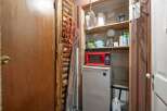 Discover practical storage solutions in this space, featuring a compact refrigerator topped with a red microwave, perfect for a small kitchen or utility area.