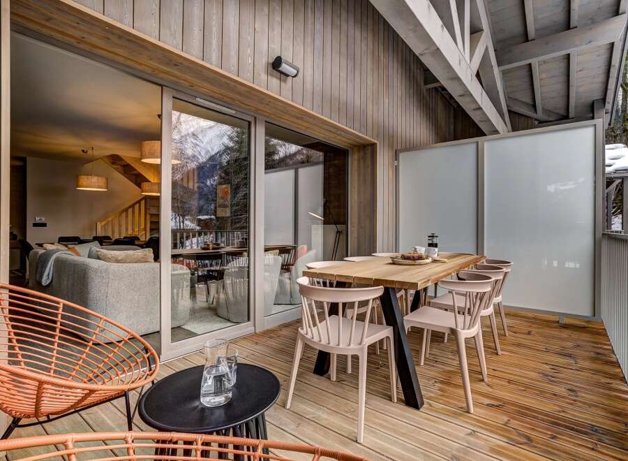 Enjoy breathtaking mountain views from this stunning modern chalet's expansive outdoor deck.