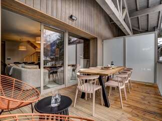 Enjoy breathtaking mountain views from this stunning modern chalet's expansive outdoor deck.