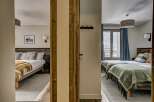 Experience comfort and style in this charming hotel room, featuring two distinct sleeping areas.