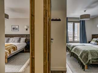 Experience comfort and style in this charming hotel room, featuring two distinct sleeping areas.