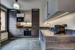 Experience modern living in this sleek kitchen featuring dark wood cabinetry and a minimalist aesthetic.