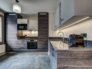 Experience modern living in this sleek kitchen featuring dark wood cabinetry and a minimalist aesthetic.