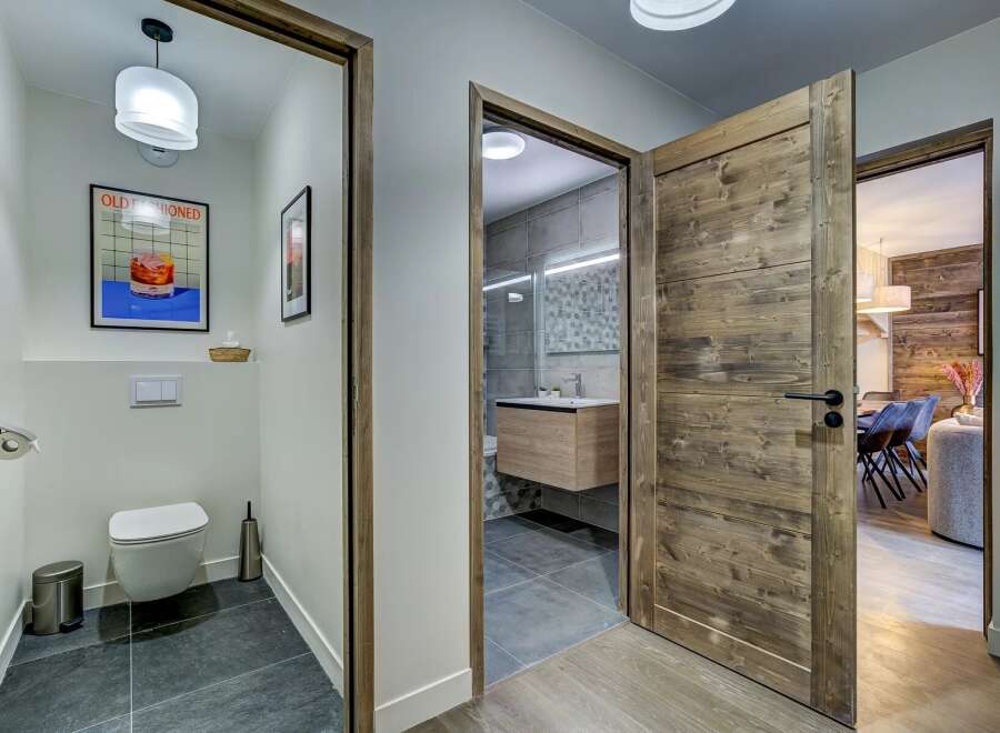 Step into a modern and inviting hallway featuring a stylish powder room with unique artwork and a sleek toilet.