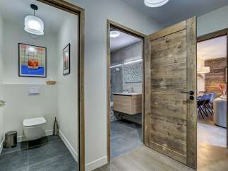 Step into a modern and inviting hallway featuring a stylish powder room with unique artwork and a sleek toilet.