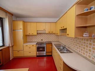 Step into this charming kitchen featuring warm yellow cabinetry and a vibrant red floor.