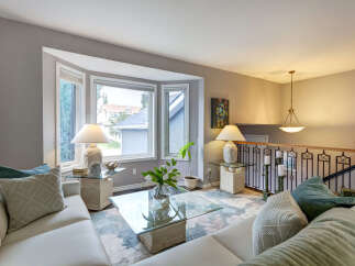 Step into this inviting living room, bathed in natural light from a large bay window.