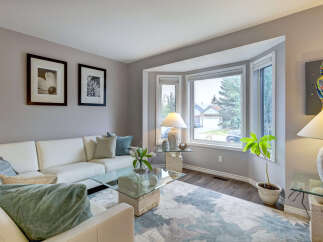 Step into this inviting living room, bathed in natural light from a large bay window.