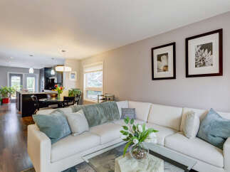 Experience modern living in this open-concept home, featuring a spacious white sectional sofa perfect for gatherings.