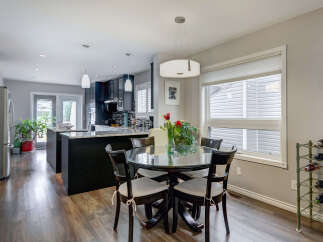 This spacious open-concept kitchen and dining area features dark cabinetry, granite countertops, and a large island perfect for entertaining.