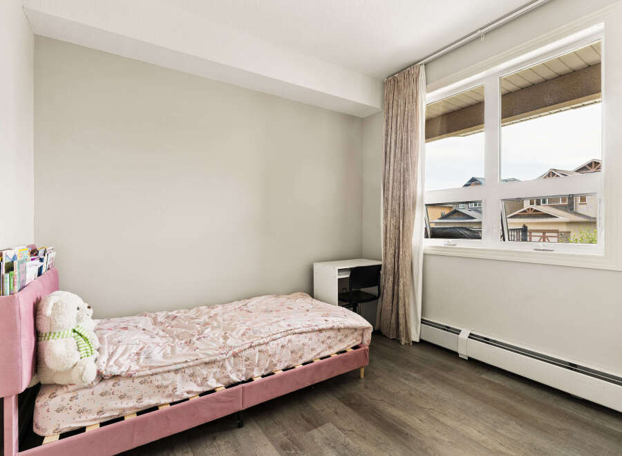 Discover this charming bedroom featuring a comfortable pink bed with a whimsical unicorn-themed comforter, perfect for a child's sanctuary.