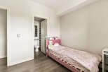 This charming bedroom features a cozy pink twin bed adorned with a whimsical unicorn-themed comforter and plush toys.