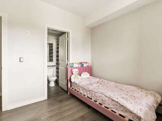 This charming bedroom features a cozy pink twin bed adorned with a whimsical unicorn-themed comforter and plush toys.