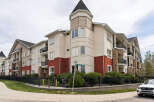 Discover modern living in this stunning apartment complex, featuring a charming turret and elegant stone accents.