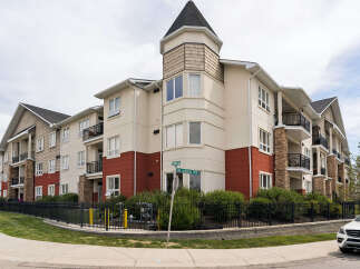 Discover modern living in this stunning apartment complex, featuring a charming turret and elegant stone accents.