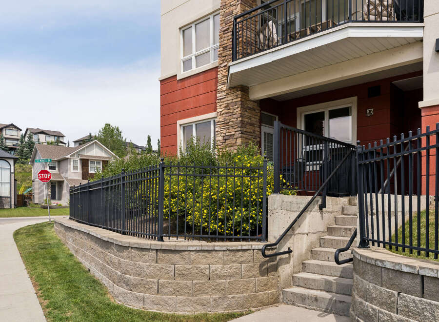 Discover modern living in this vibrant apartment complex, featuring a striking facade with red and stone accents.