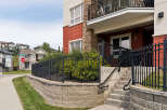 Discover modern living in this vibrant apartment complex, featuring a striking facade with red and stone accents.