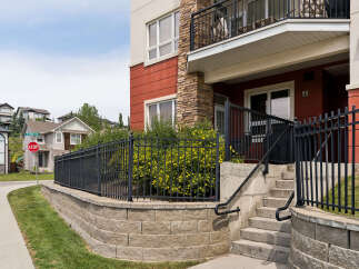 Discover modern living in this vibrant apartment complex, featuring a striking facade with red and stone accents.
